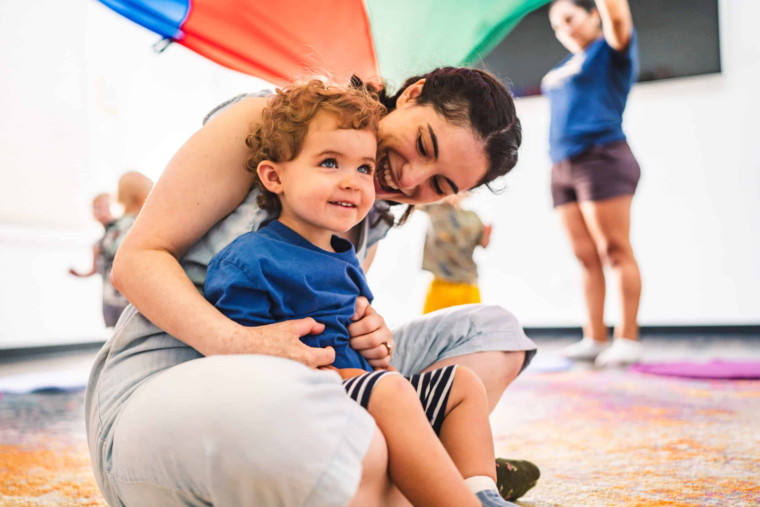 Baby sitting on mother's lap enjoying a preschool session