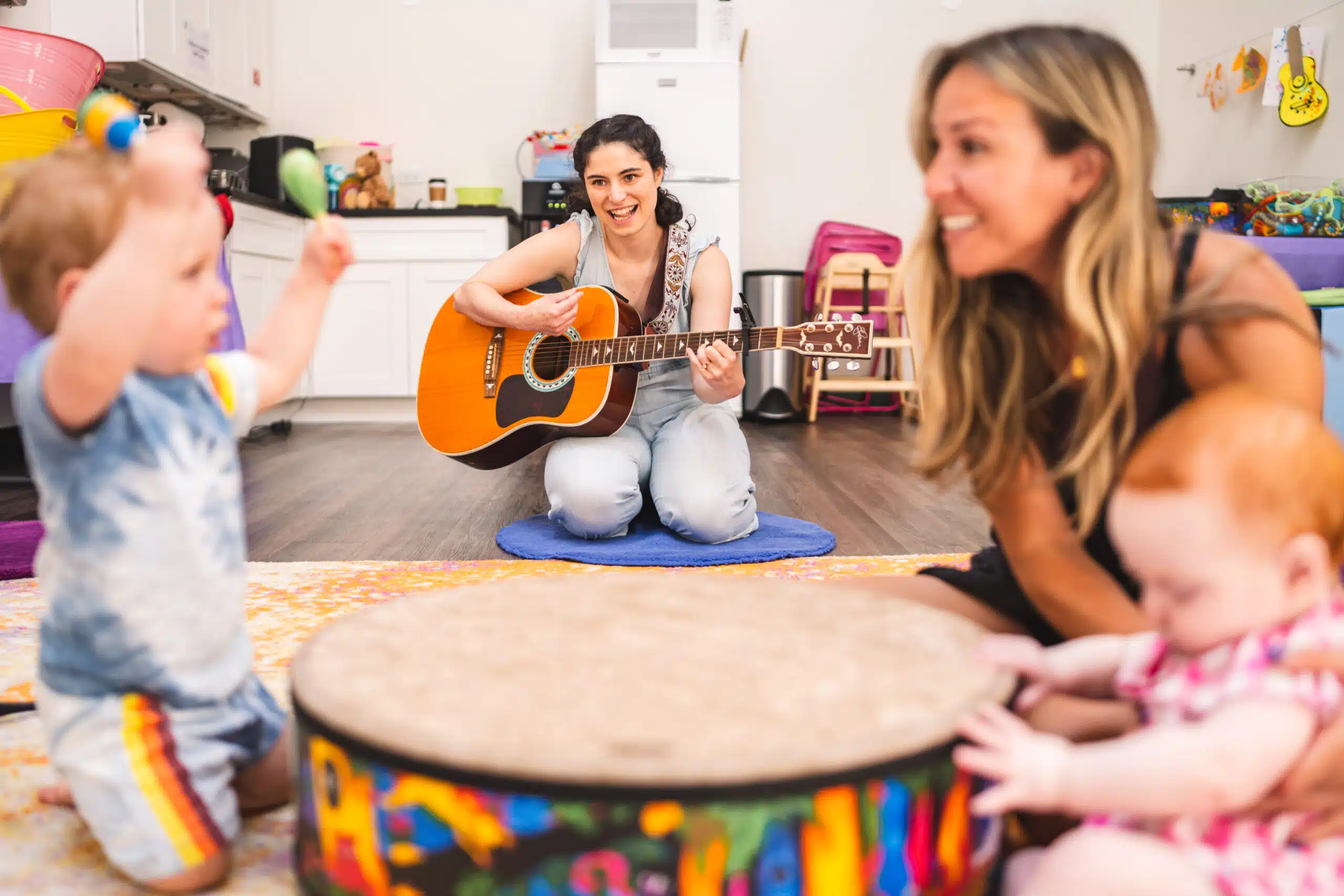 Parent and children playing the drum in music class
